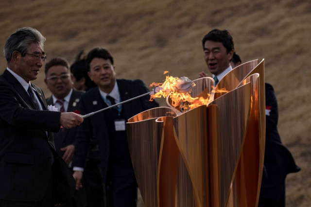 Olympic flame gets muted welcome in Japan as Games doubts grow