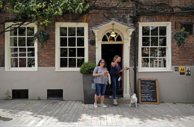 Beer flows, masks come off as England reopens pubs