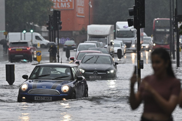 London roads flood as storms roll in